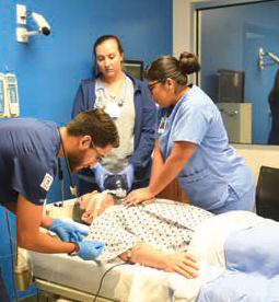 Chris Mendoza assisting in mannequin nursing exercise